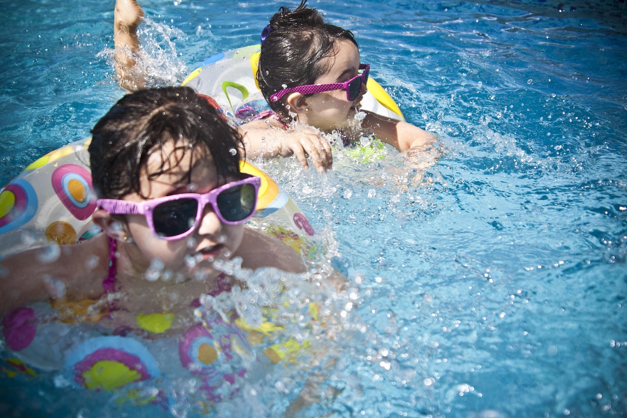 girls, swimming, splashing, sisters, little girls, floaters, swim, swimming pool, pool, summer, vacation, splashing water, childhood, nature, children, kids, shades, sunglasses, people, water, cute, wet, young, happy, joy, fun, activity, happiness